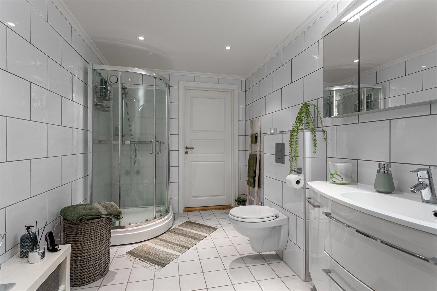 Badet har downlights i tak, varmekabler i gulv og dusjkabinett (2017).