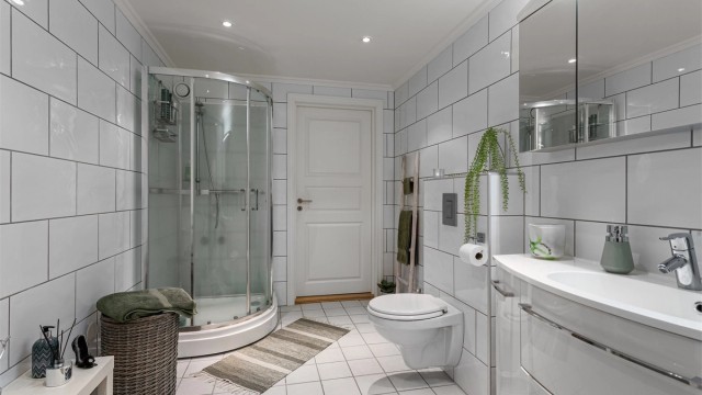 Badet har downlights i tak, varmekabler i gulv og dusjkabinett (2017).