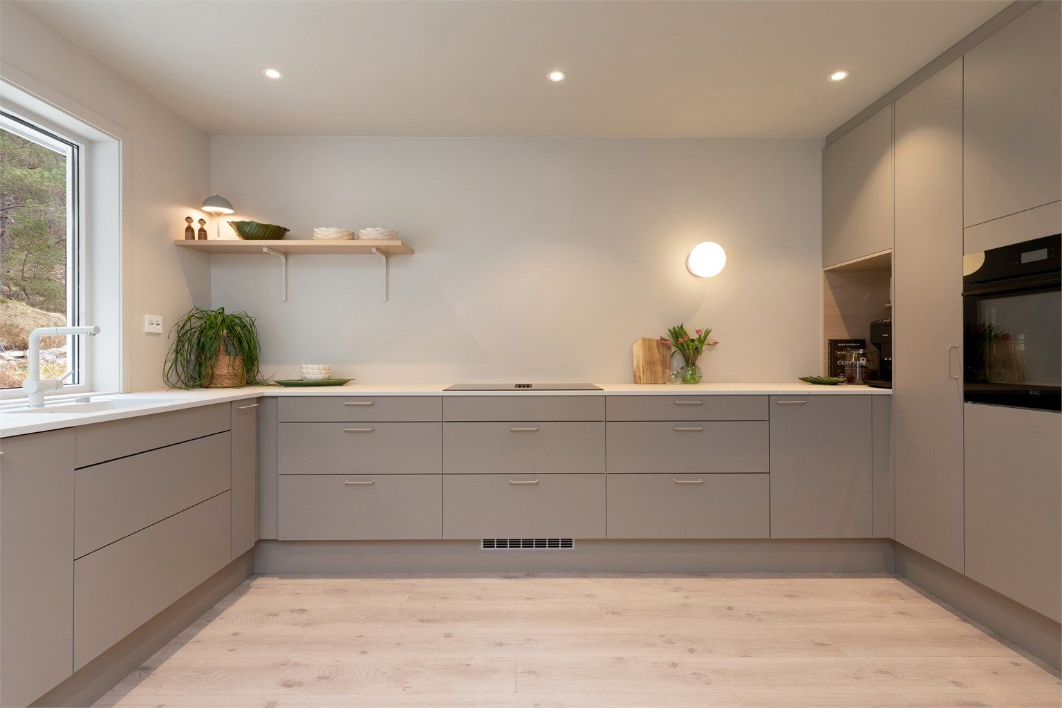 Nytt og påkostet HTH-kjøkken med glatte fronter og laminat benkeplate.