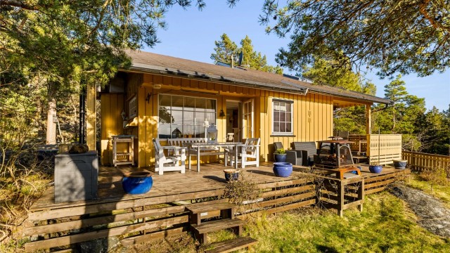 PÅ TERRASSEN: På hele hyttas vestside løper en stor og til dels overbygget terrasse. Takoverbygg gjør det lettvint å ha møbler stående ute og bidrar til lune uteplasser.