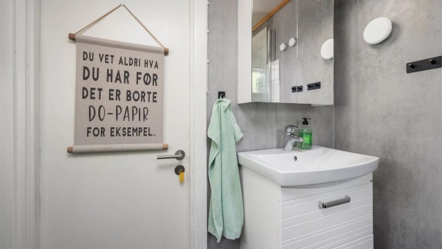 Badet har servantskap med overskap med speil og lys.