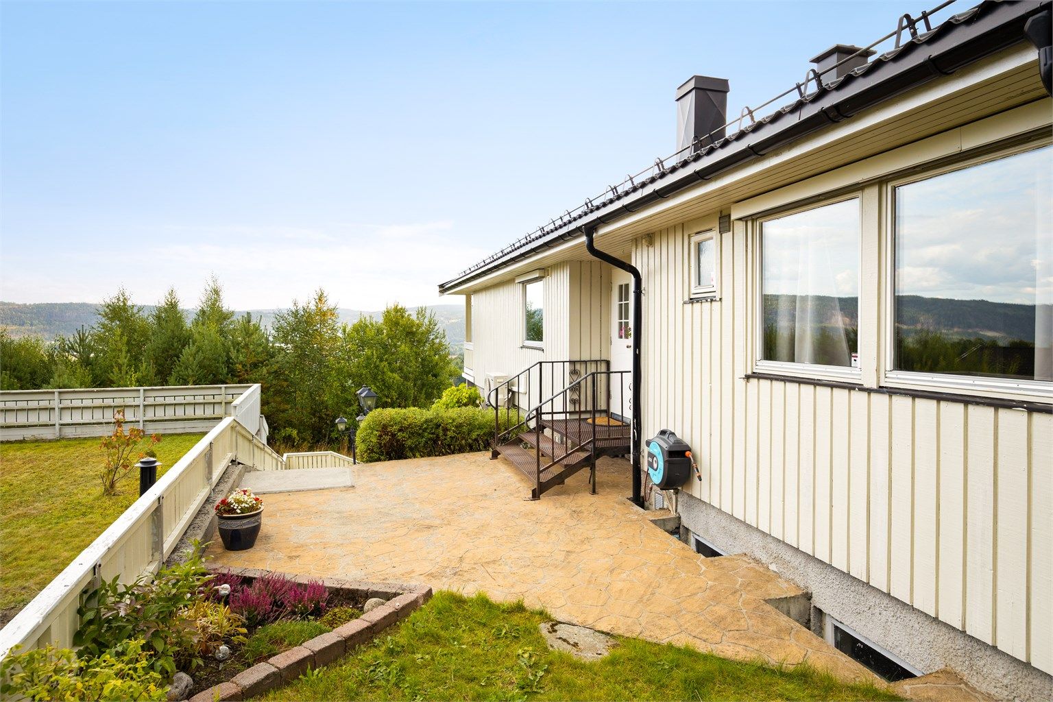 Fra gårdsplassen er det utvendig trapp med videre adkomst til boligens overbygde inngangsparti i 1. etasje.