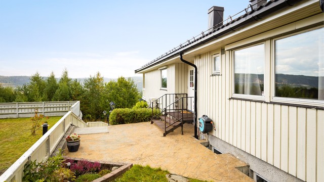 Fra gårdsplassen er det utvendig trapp med videre adkomst til boligens overbygde inngangsparti i 1. etasje.