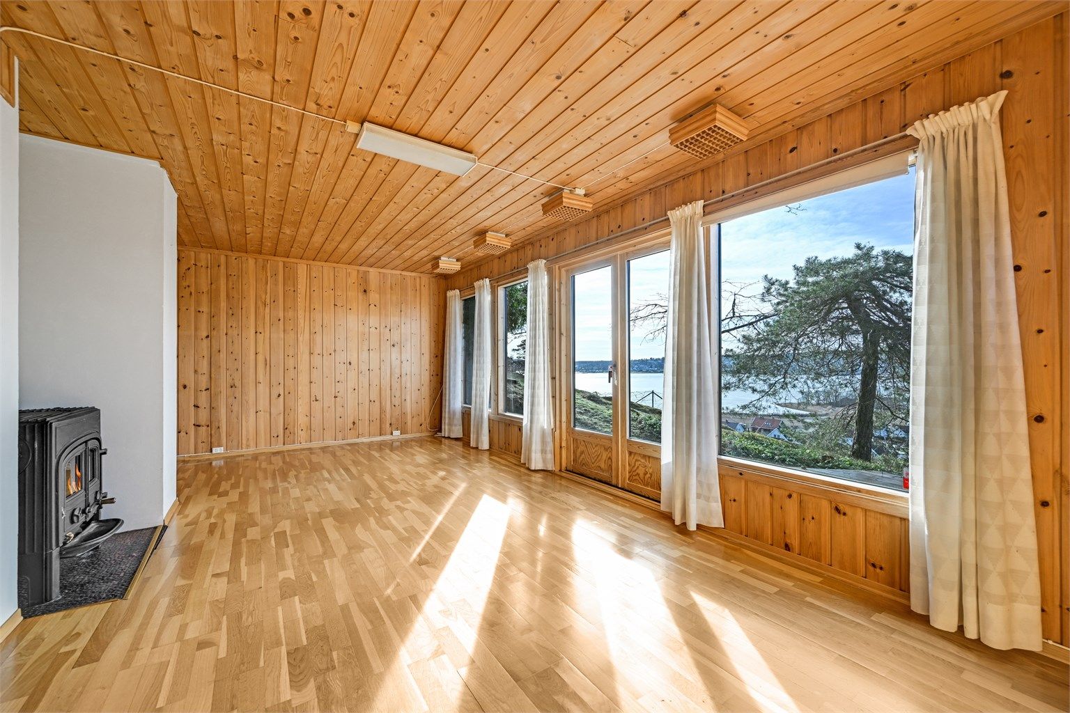 Her får du en stue med en flott kombinasjon av varme materialer og høyt lysinnslipp.