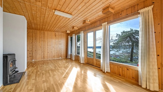 Her får du en stue med en flott kombinasjon av varme materialer og høyt lysinnslipp.