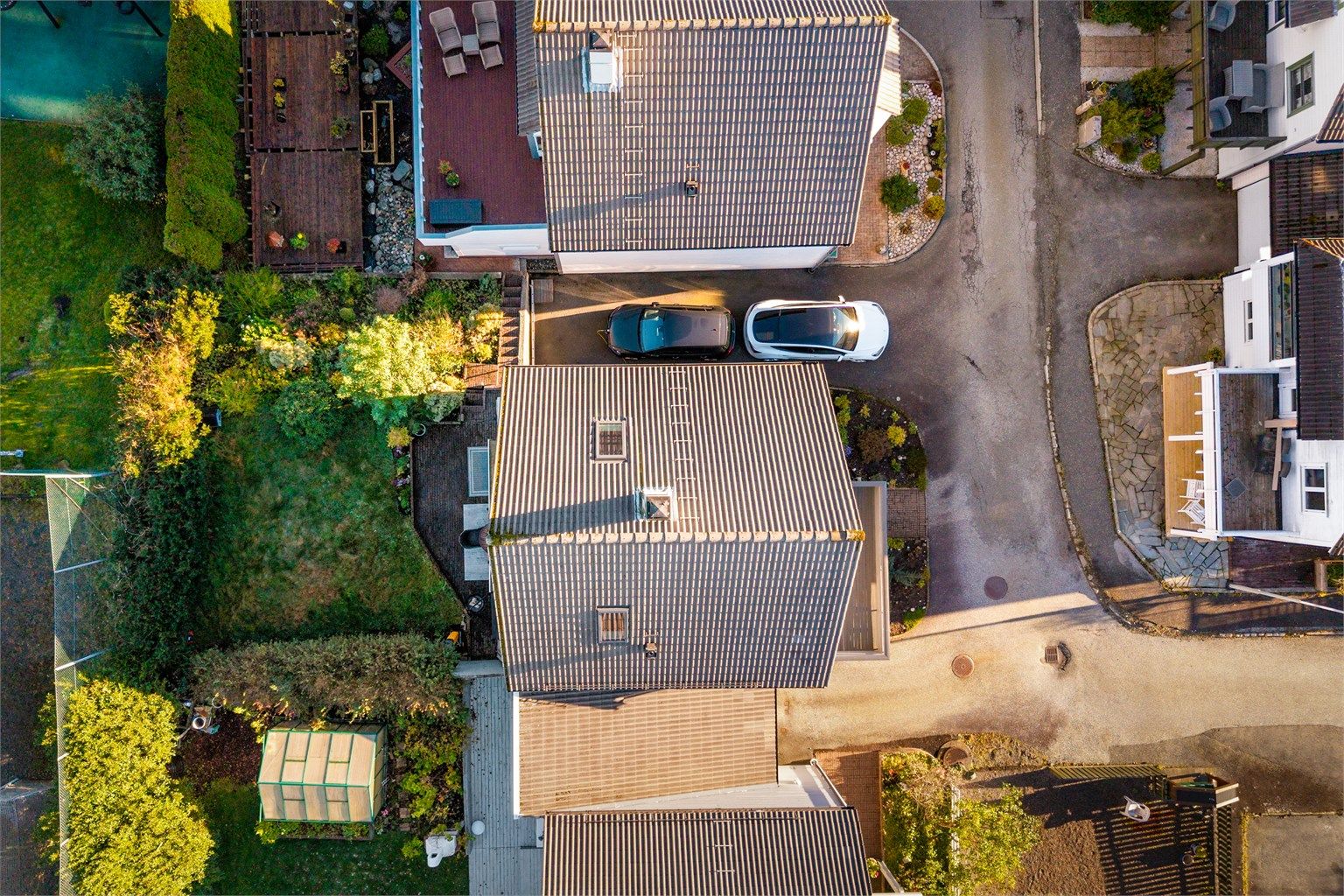 Tomten har opparbeidet hage, carport og asfaltert gårdsplass.