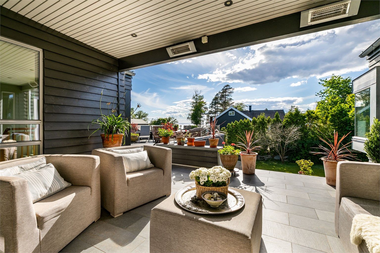 På terrassens inntrukne del er det lunt og vel så fin sjøutsikt å se. Varmelamper høyner trivselsgraden på lyse sommerkvelder.