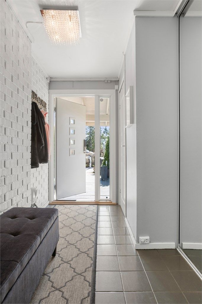 Lys og innbydende entré med skyvedørsgarderobe med speilfronter. 