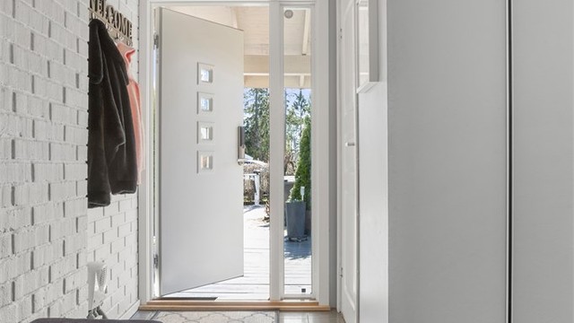 Lys og innbydende entré med skyvedørsgarderobe med speilfronter.