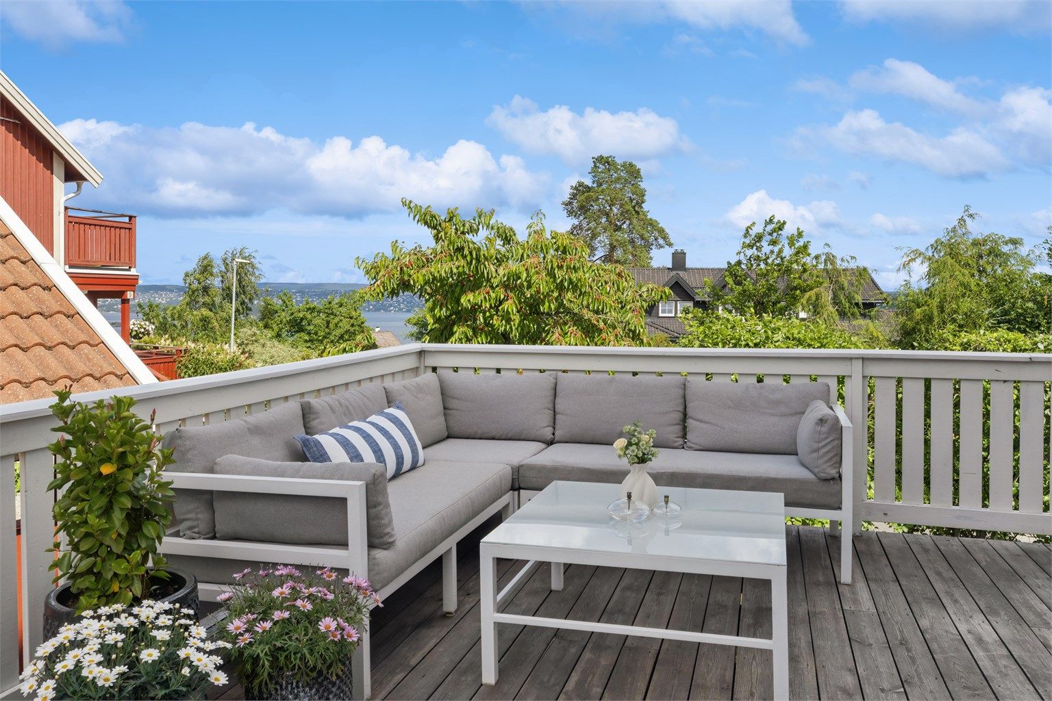 Stor og solrik terrasse på 77 m² med god plass til både spisegruppe, loungeområde og fjordutsikt
