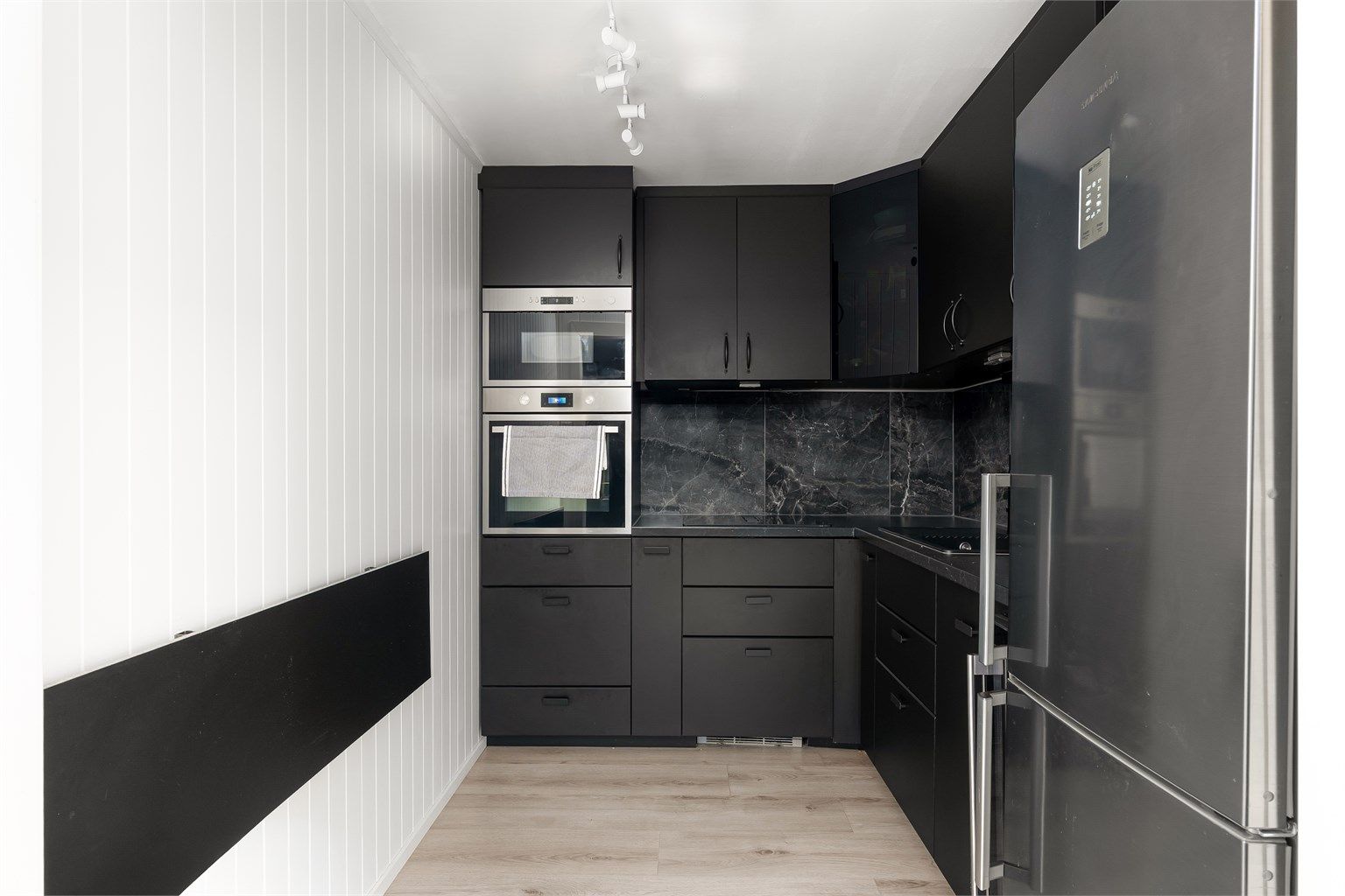 Stilrent kjøkken fra 2022 med integrerte hvitevarer.