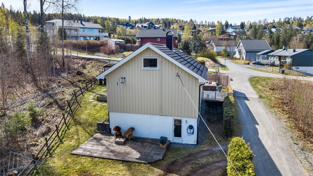 Eiendommen sett fra siden, med hage og terrasseplatting. Utsiden av boligen ble malt i sommer.