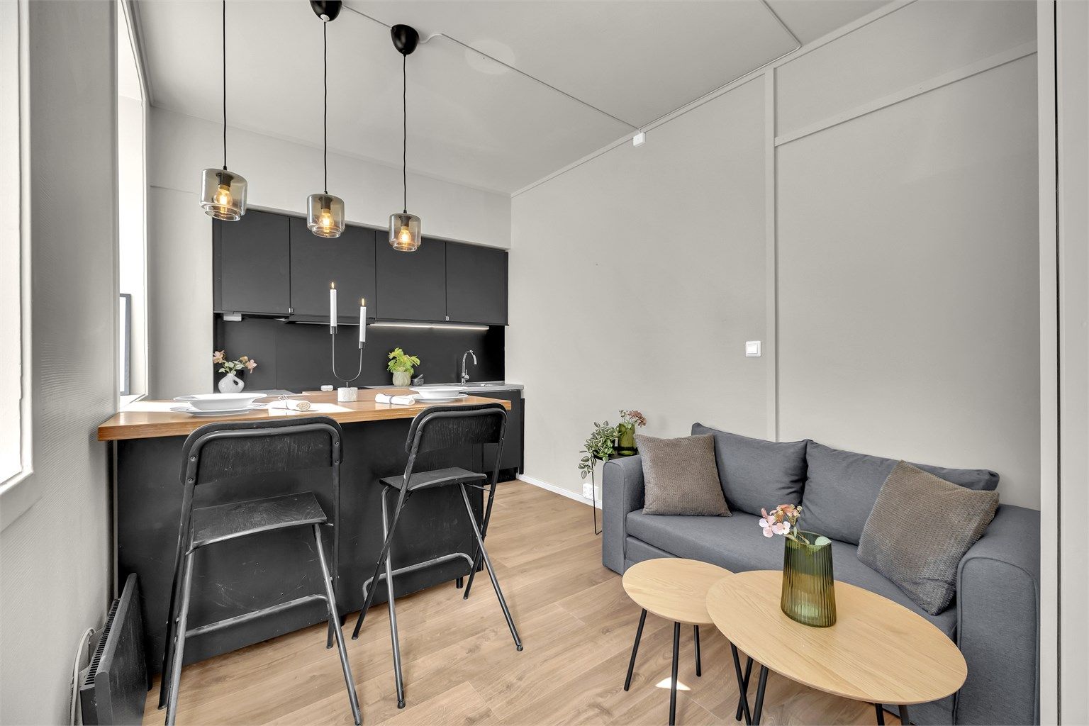 Åpen stue-/kjøkkenløsning med integrerte hvitevarer.