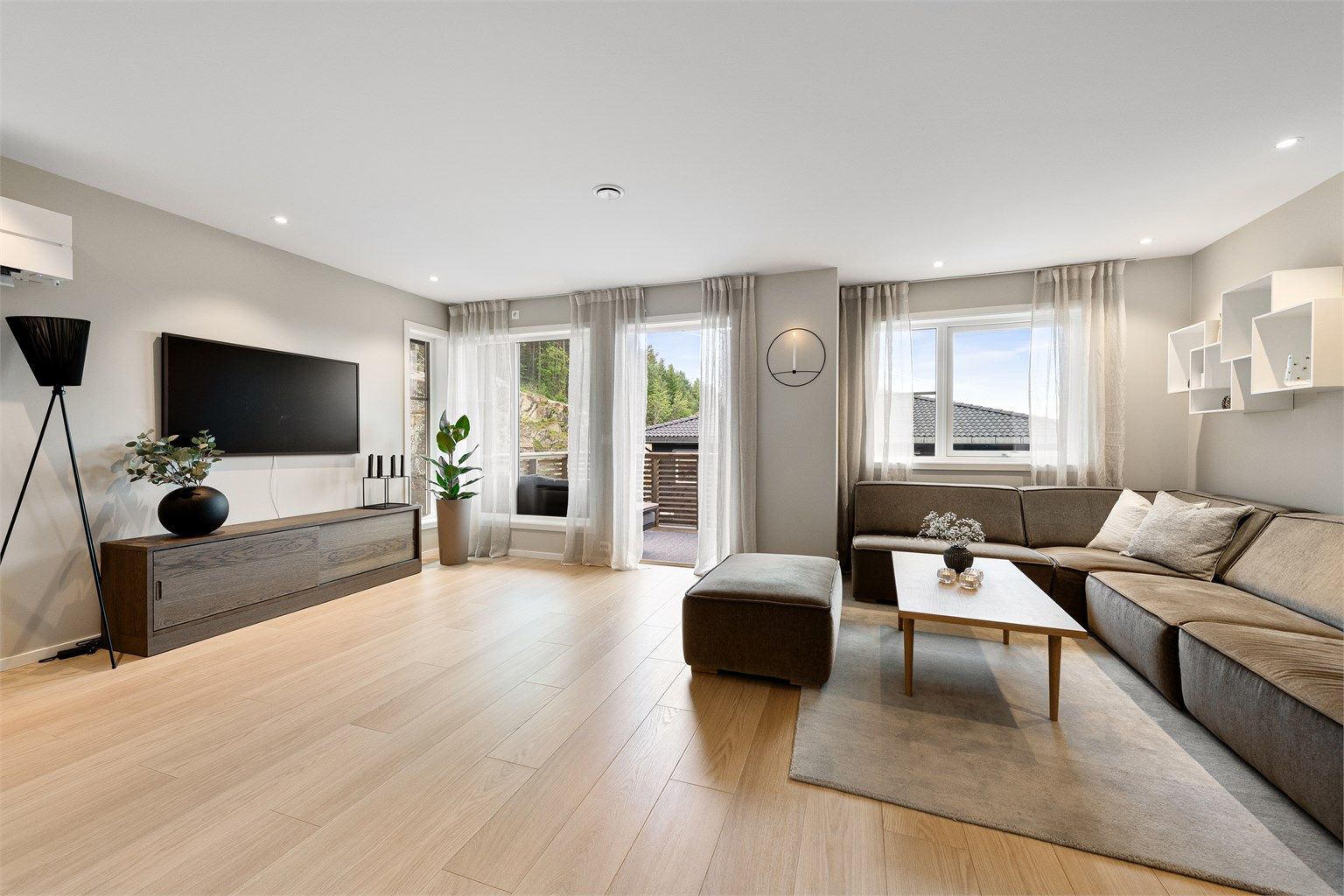 Lys og lekker stue med store vindusflater som gir gode lys og utsiktsforhold.