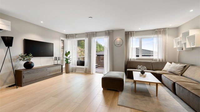 Lys og lekker stue med store vindusflater som gir gode lys og utsiktsforhold.