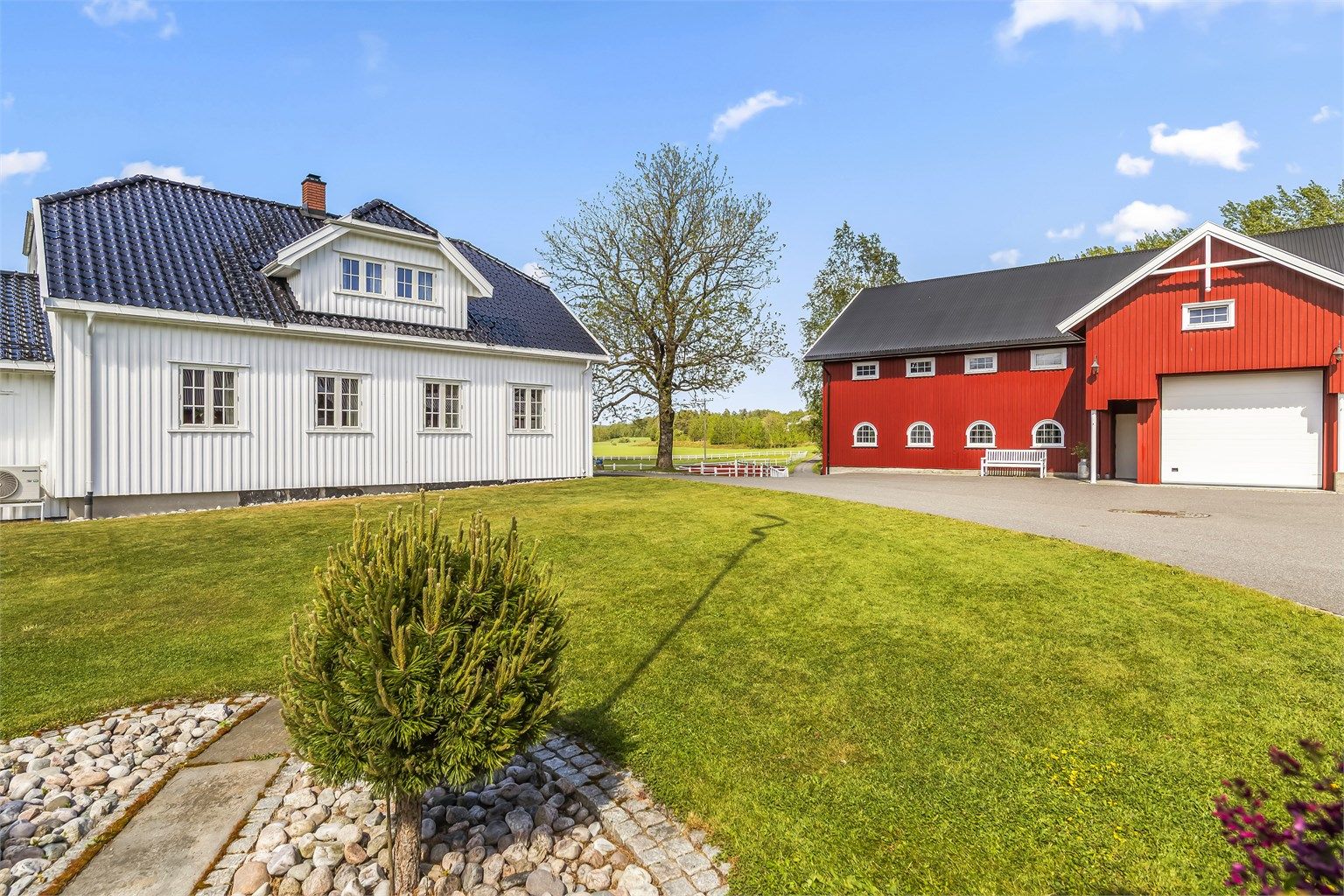 Våningshuset er klassisk pent med glasert takstein.