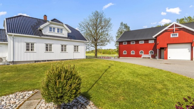Våningshuset er klassisk pent med glasert takstein.