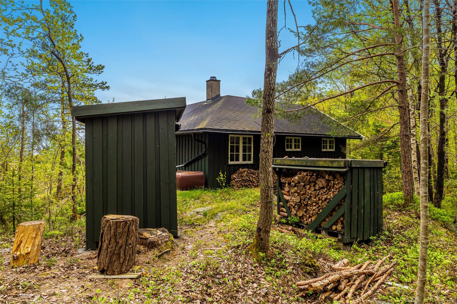 Bak hytta er det et lite enkelt uthus.