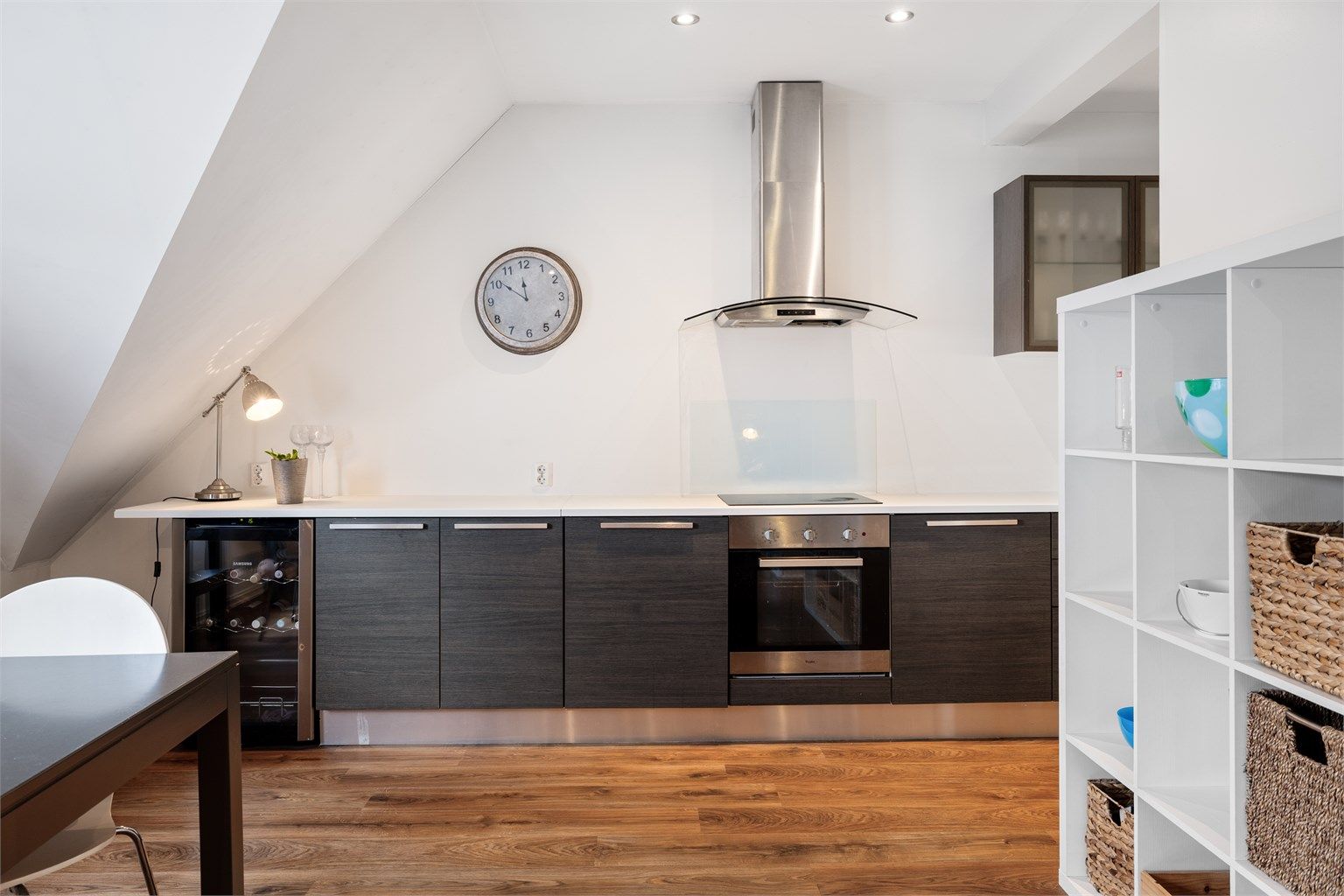I kjøkkeninnredningen er det integrert stekeovn og platetopp nedfelt i benkeplaten med laminert overflate. Videre er det frittstående oppvaskmaskin, kjøleskap med fryser og vinskap