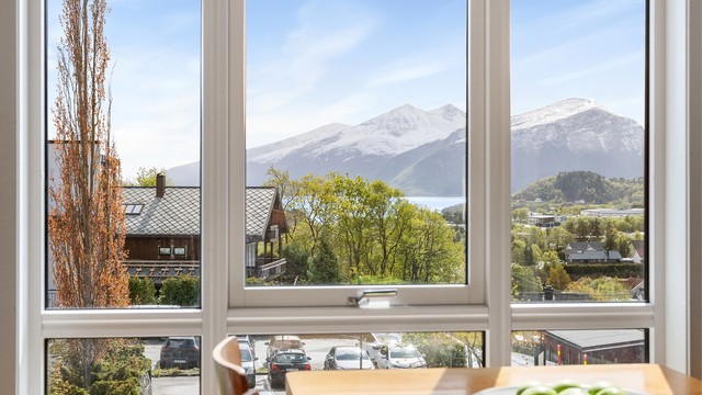 Store vindusflater i stuen slipper inn rikelig med dagslys og rammer inn utsikten.