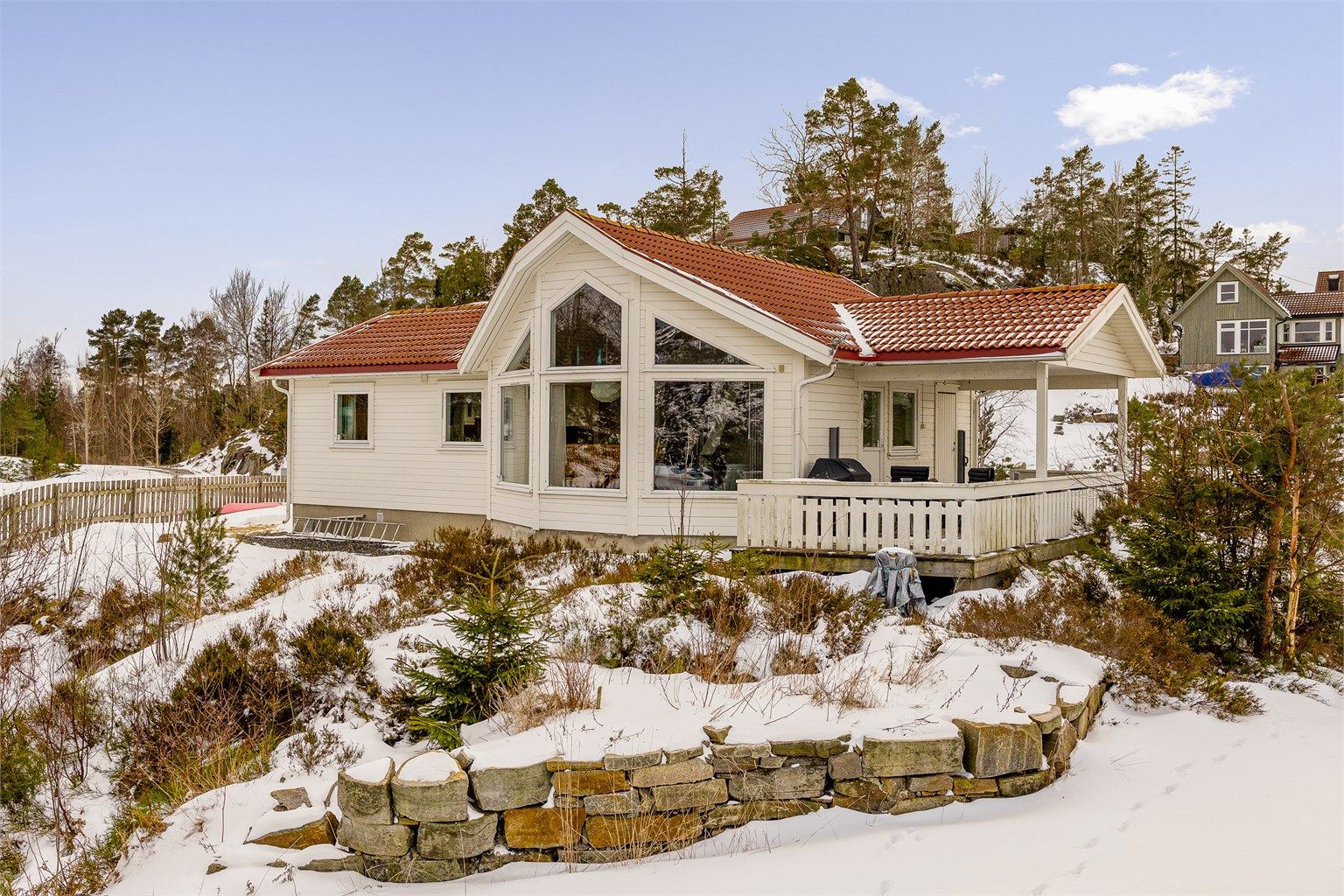 Hytta har store vinduer som slipper inn riklig med naturlig lys