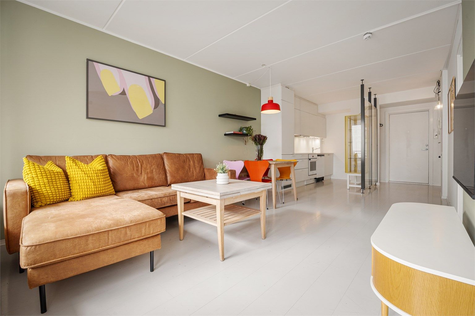 Stuen har plass til både sofagruppe og spisebord og ligger i åpen løsning til kjøkkenet.