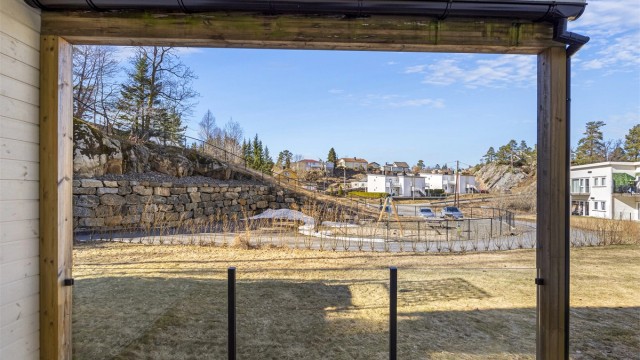 Uteområdet er flott opparbeidet med hekker som snart blomstrer, murer, lekeplass og p-plass felles med de andre leilighetene på veien inn.