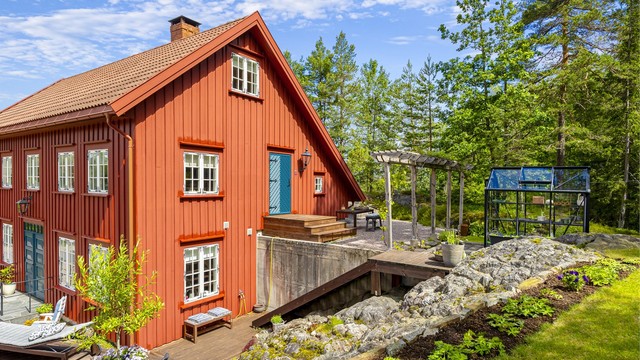 Boligen er bygget på en skrånende tomt med forstøtningsmurer i betong.