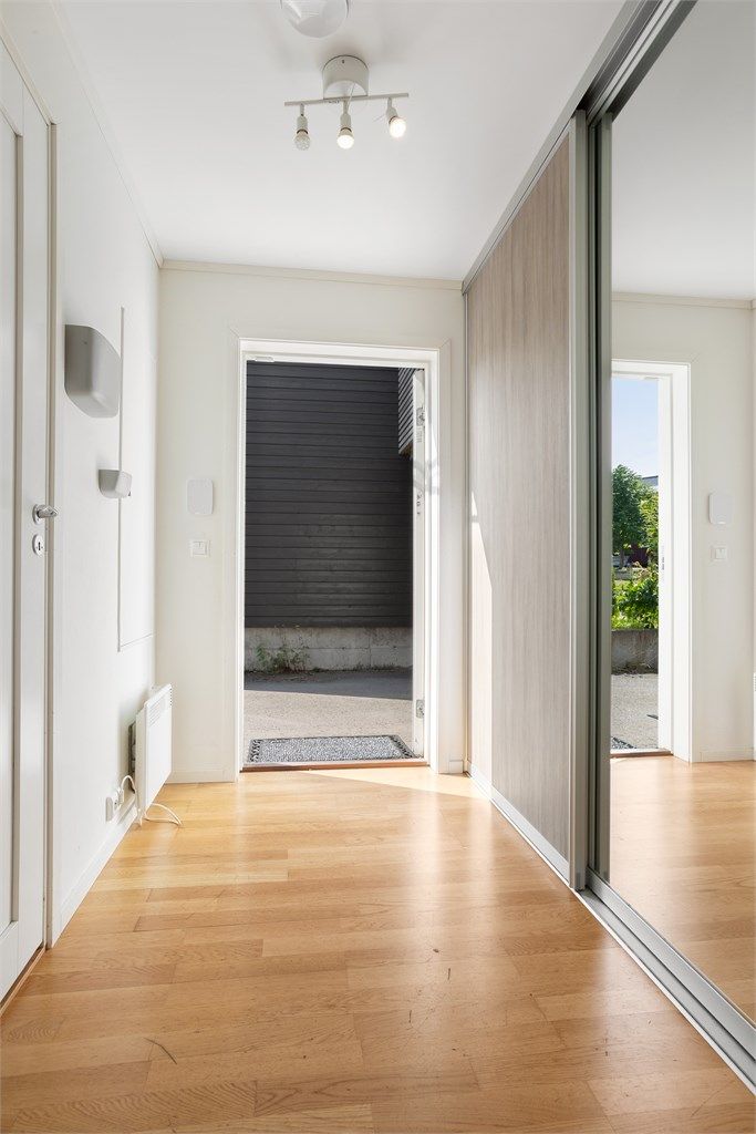 Lys entré med skyvedørsgarderobe og adkomst til en praktisk innvendig bod.