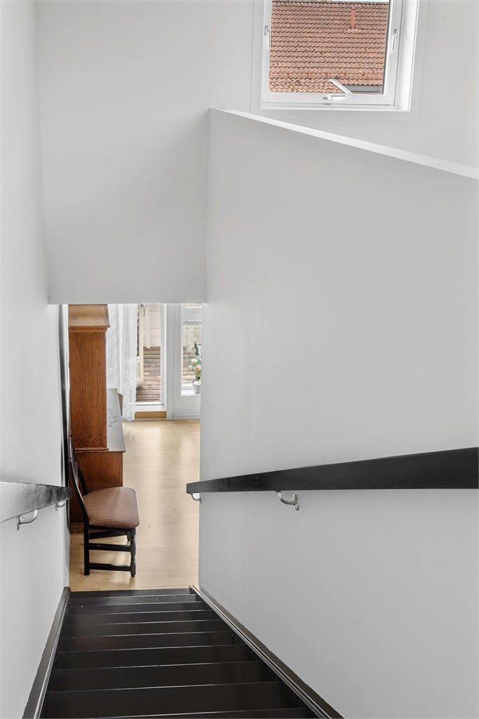 Den malte tretrappen binder de tre etasjene sammen på en effektiv måte.