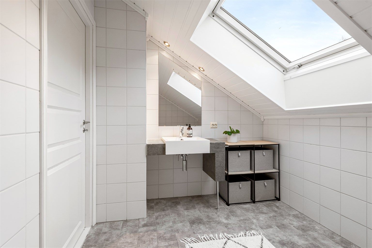 Badet i loftsetasjen er helfliset og utstyrt med badekar.