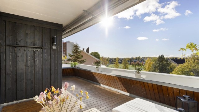 Terrassen er på hele 13 kvm, har gulv belagt med terrassebord, blomsterkasse som rekkverk og markise.