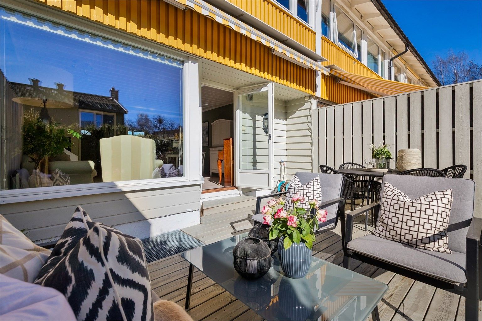 En markise over vinduet og terrassedøren gir behagelig skygge på varme dager.