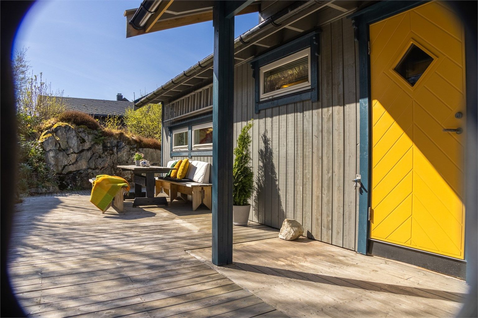 Velkommen inn! Innbydende inngangsparti med terrasse som strekker seg rundt 2/4- deler av hytta. 