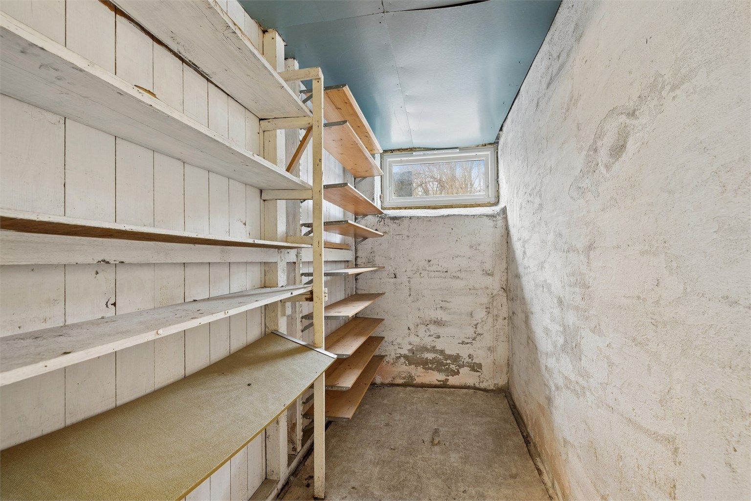 En av de mange bodene i kjelleren, med praktiske hyller for organisering.