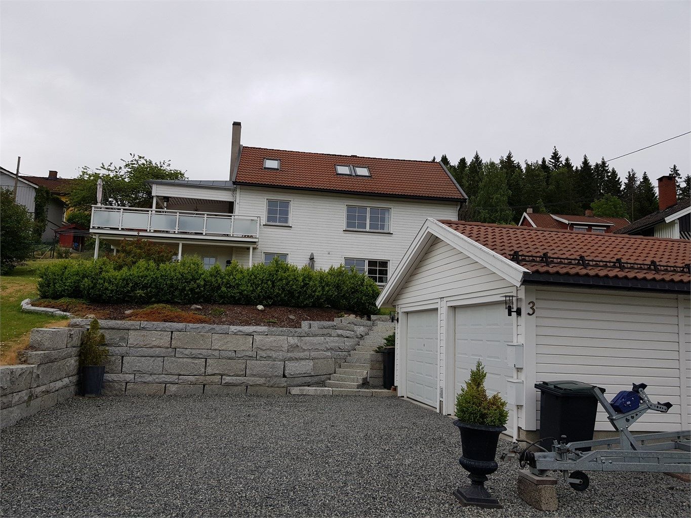 Singlet gårdsplass med god plass til parkering foran garasjen.