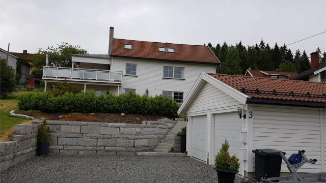 Singlet gårdsplass med god plass til parkering foran garasjen.
