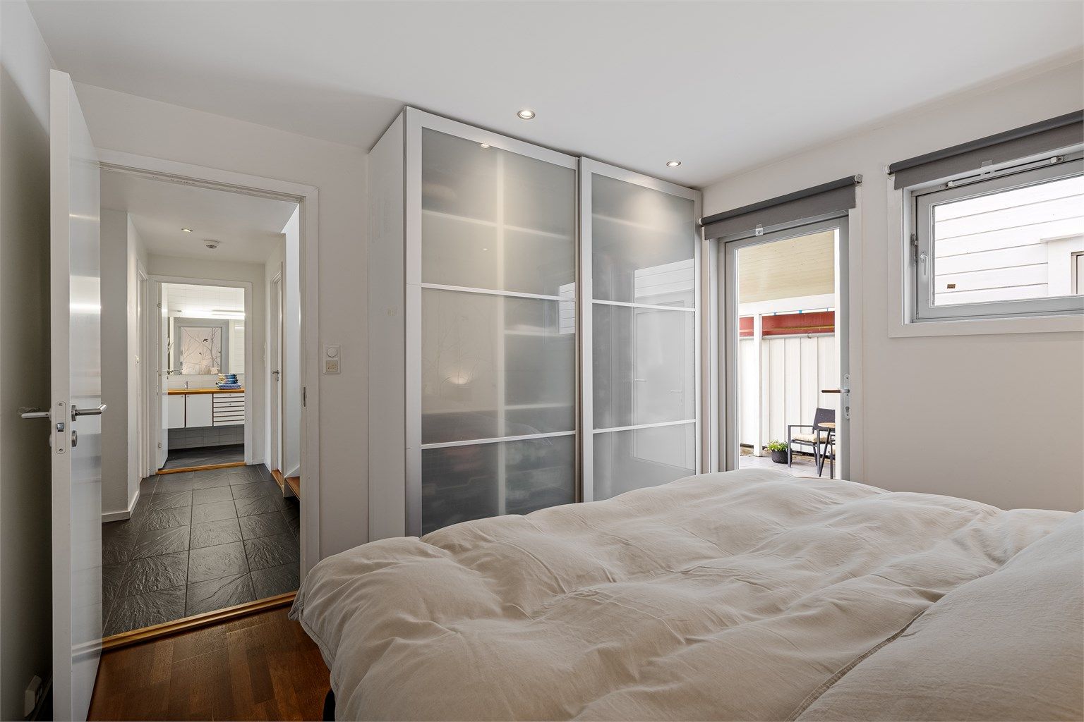 Det er har parkett på gulv, malte veggflater og tapet, romslig skyvedørsgarderobe med rikelig oppbevaringsplass og plass til stor dobbeltseng og nattbord. 