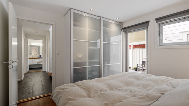 Det er har parkett på gulv, malte veggflater og tapet, romslig skyvedørsgarderobe med rikelig oppbevaringsplass og plass til stor dobbeltseng og nattbord.