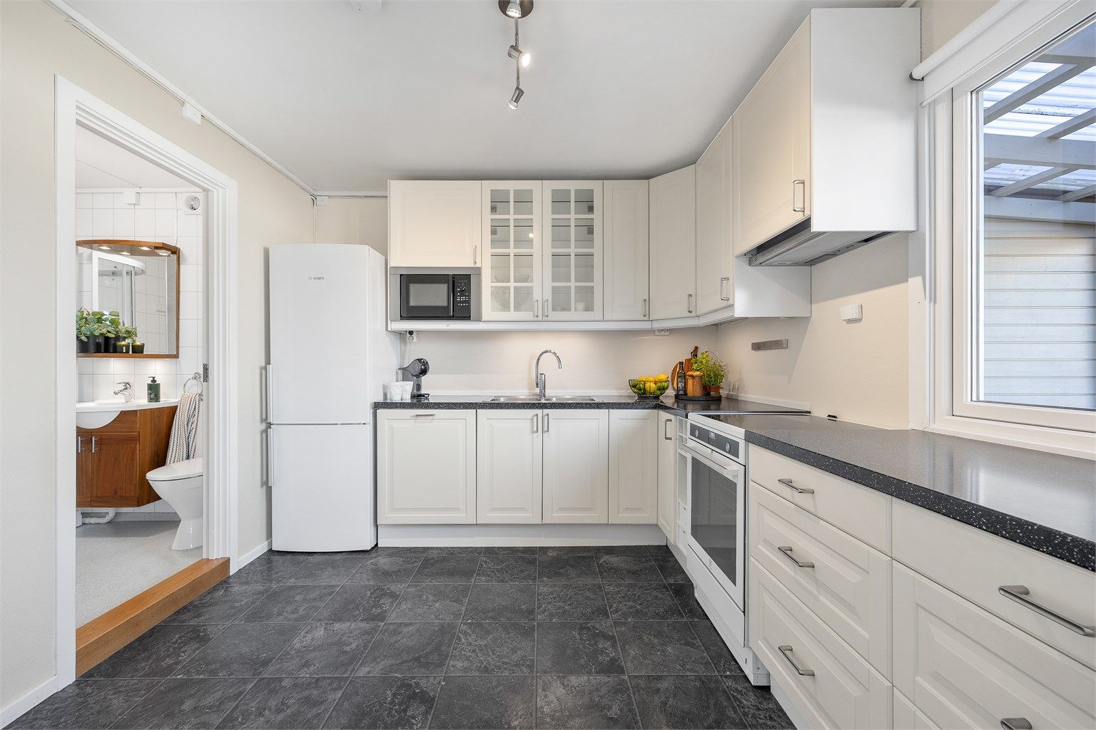 Praktisk kjøkken med god skap- og benkeplass. Fra kjøkkenet er det adkomst til et av boligens bad.