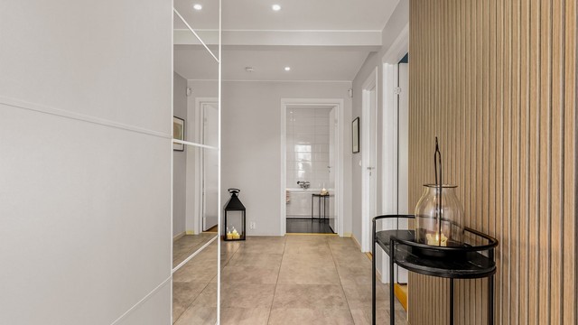 Spilevegg i eik og skyvedørsgarderobe med speilfronter gir en stilren velkomst. Og vi beveger oss opp til hovedetasjen.