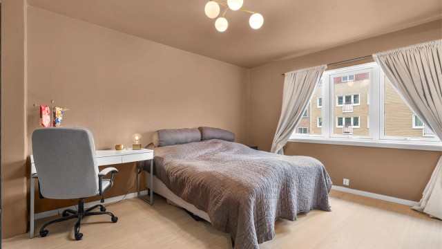 Hovedsoverommet har god plass til dobbeltseng og en praktisk kontorplass ved vinduet.