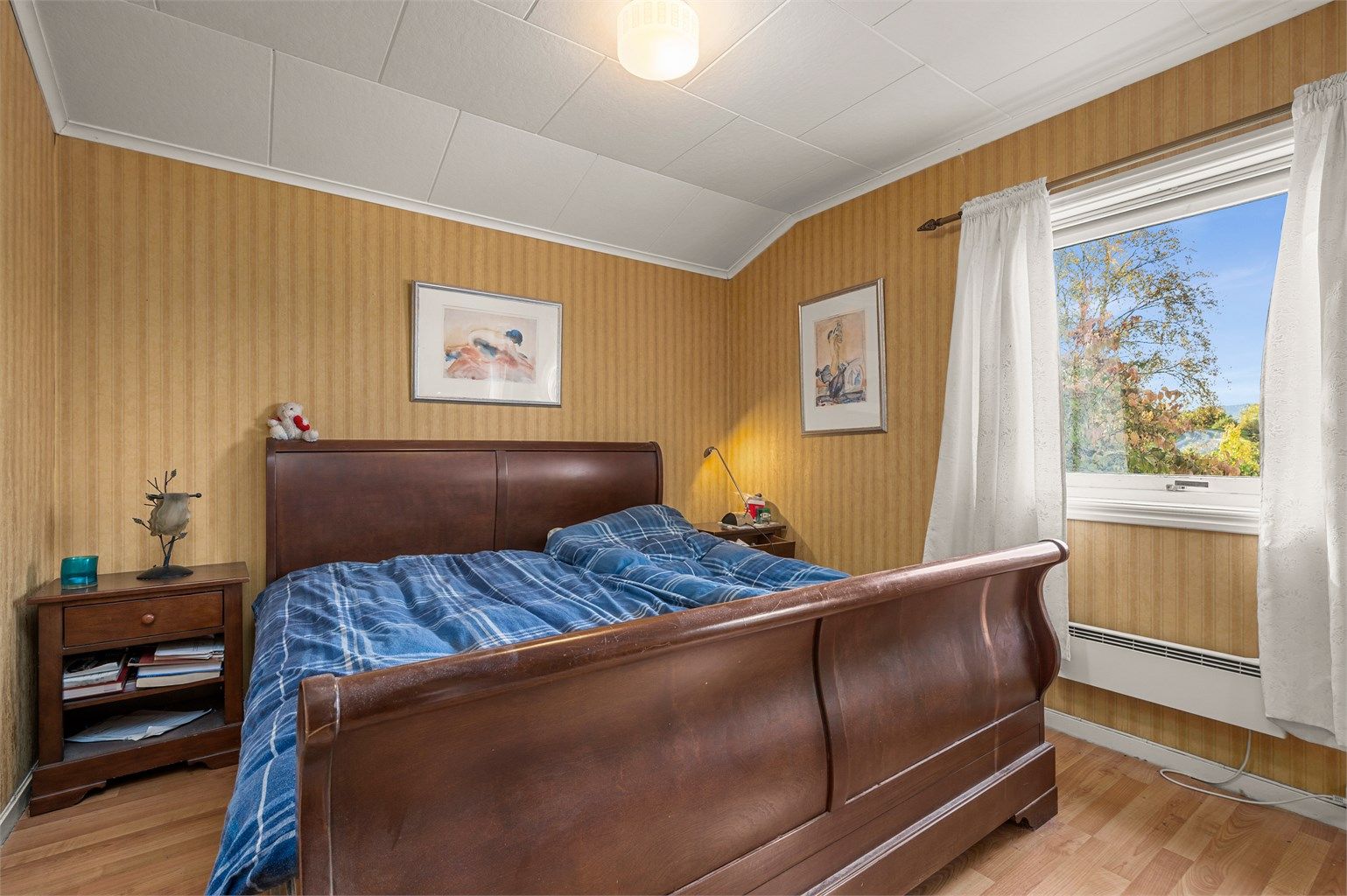 Romslig soverom med plass til dobbeltseng og nattbord.