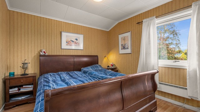 Romslig soverom med plass til dobbeltseng og nattbord.