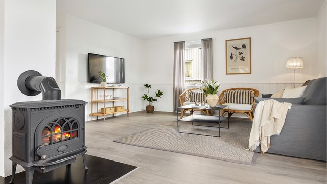 En vedovn i stuen gir lun varme og en hyggelig atmosfære på kjølige dager.