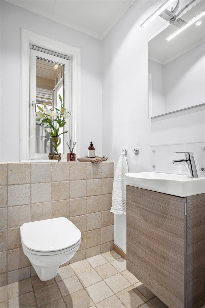 Praktisk toalettrom, oppgradert i 2009, med flislagt gulv og vegghengt toalett.