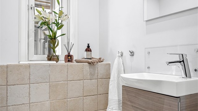 Praktisk toalettrom, oppgradert i 2009, med flislagt gulv og vegghengt toalett.