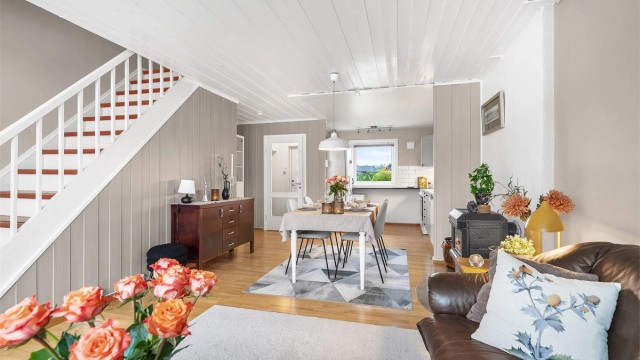 Boligen har en åpen stue- og kjøkkenløsning, med peis som skaper en lun og innbydende atmosfære