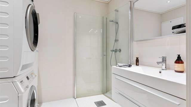 Badet i første etasje er helfliset og har gulvvarme. Her er det dusjhjørne og opplegg for vaskesøyle