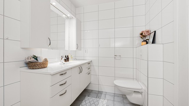 Badet har flislagte overflater, gulvvarme og innredning fra HTH.